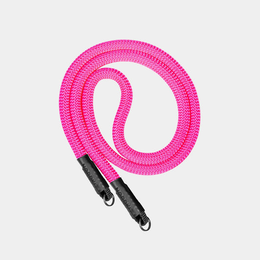 Nordkit Kameragurt in leuchtendem Neonpink mit schwarzen Befestigungen und Nordkit-Logo