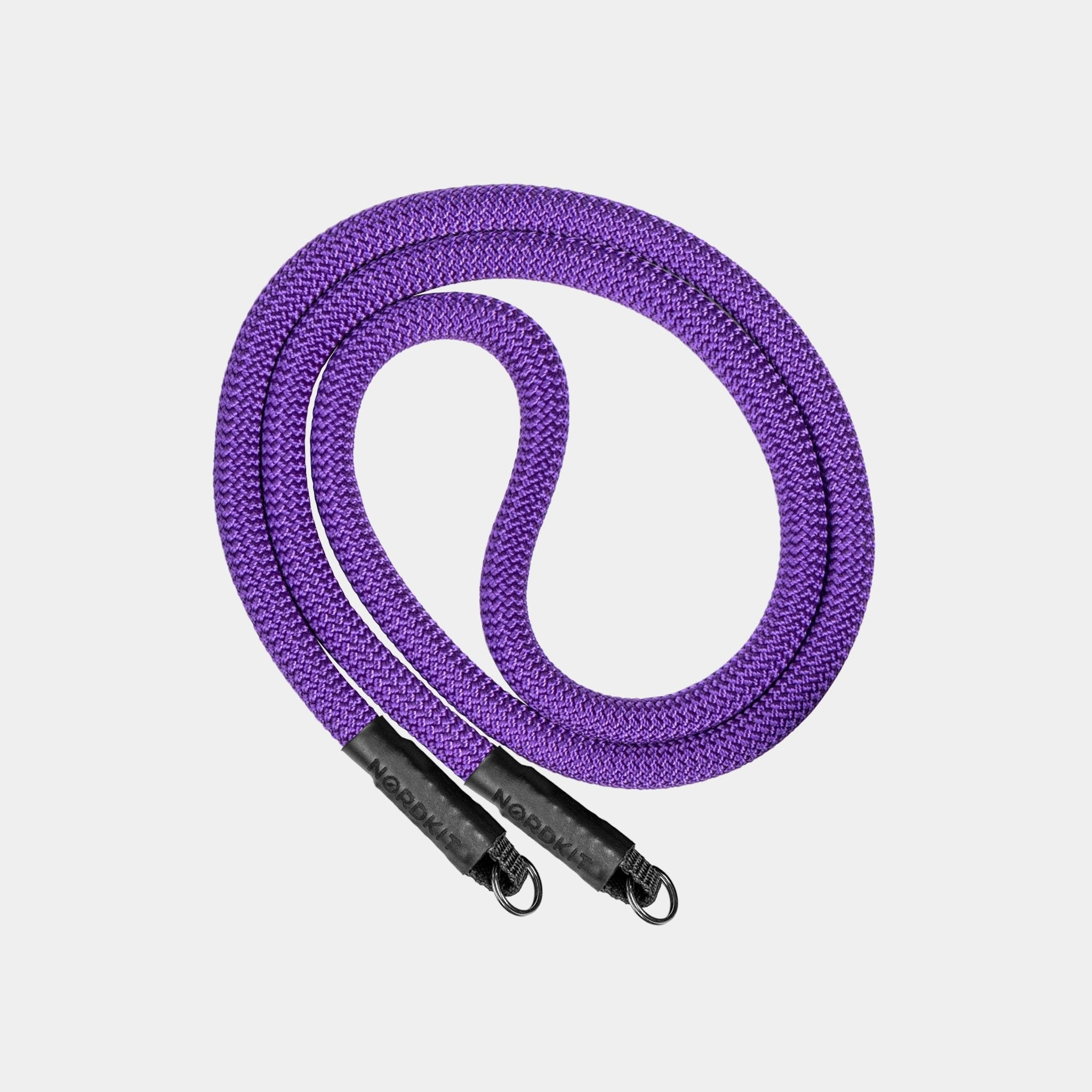 Nordkit Kameragurt in tiefem Lila mit schwarzen Befestigungen und Nordkit-Logo